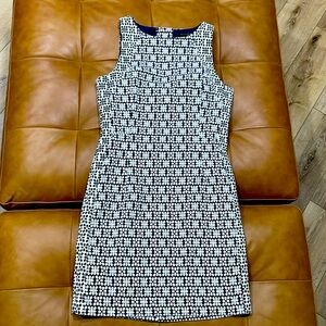 Patterned navy blue and white fitted dress with opening in upper back.